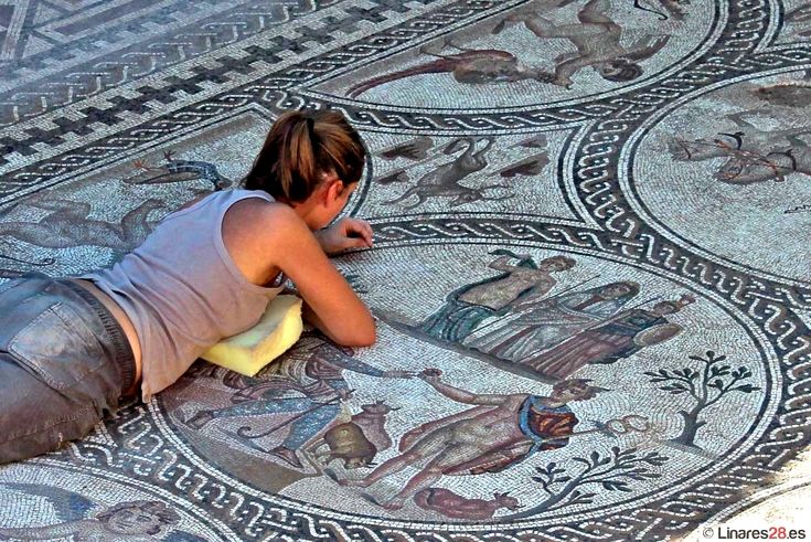 This may contain: a woman laying on the ground next to a mosaic