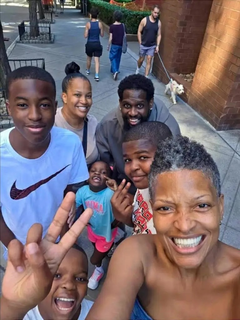 Alisa Goods and her family smiling for a selfie on a city sidewalk.