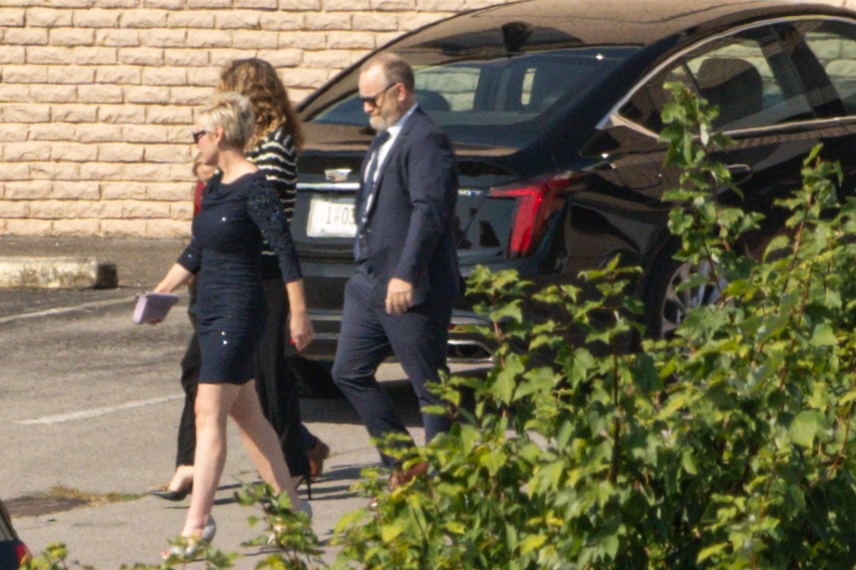 Bryan Seaver and two other individuals, possibly family of Dolly Parton, walking outside Woodlawn Funeral Home.